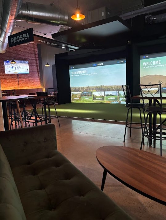 Les baies de simulateurs et le coin lounge du Golf Lounge Sherbrooke