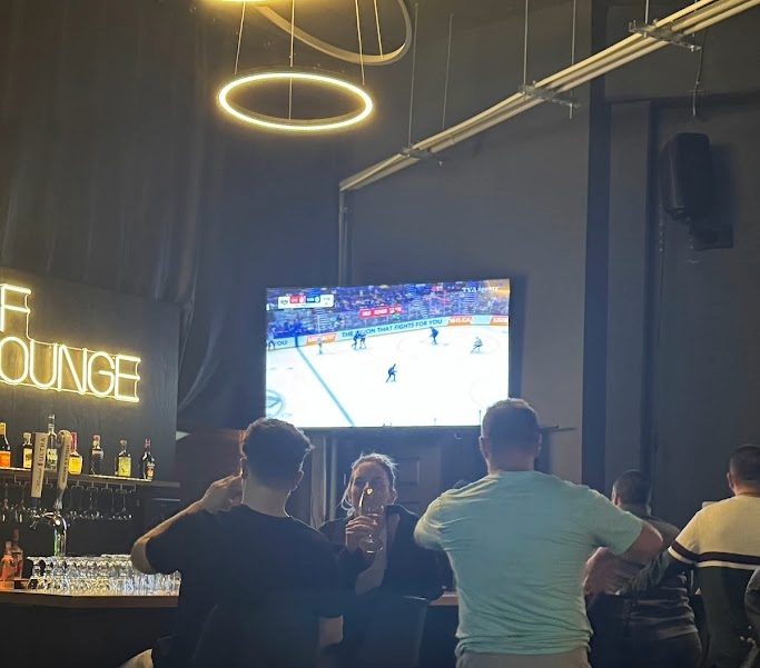 Des clients regardent le match de hockey au bar du Golf Lounge